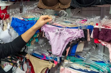 Female hands with seductive lace lingerie in shop