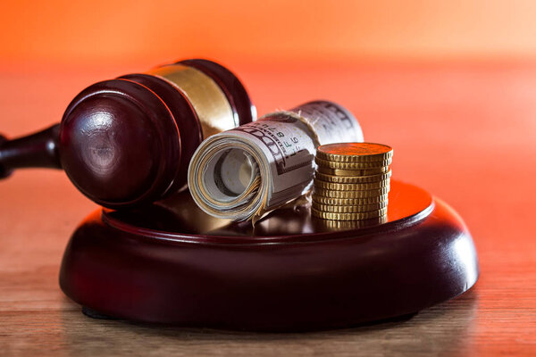 Dollar banknotes in bundle with wooden judge's gavel