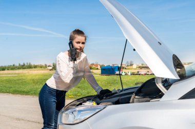 Aracı bozulmuş bir sürücü telefon görüşmesi yapıyor.