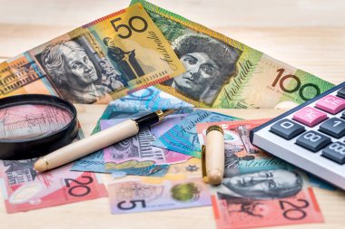 Kalem, büyüteç ve hesap makineli Avustralya Doları