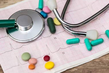 Stetoskop kardiyogramda tablet ve şırınga ile