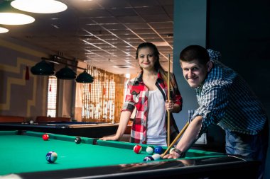 Bilardo oynayan arkadaşlar, topa vuran bir adam.