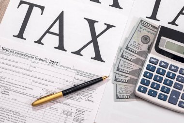 Dolar, hesap makinesi ve kalemle birlikte 1040 vergi formu