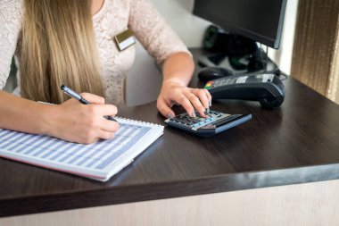 Güzellik salonunun yöneticisi planlayıcıya notlar yazıyor.