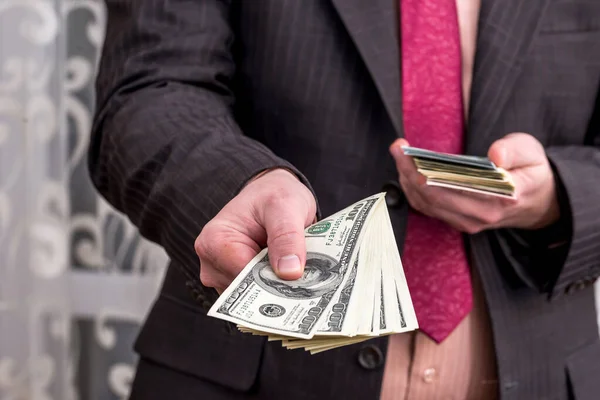 スーツを着たビジネスマンがドル紙幣を提供し クローズアップ — ストック写真