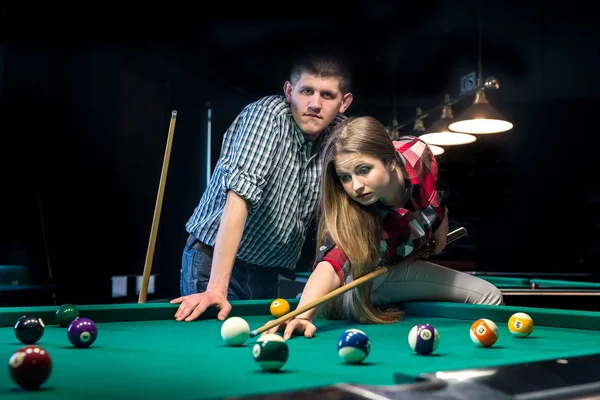 Bilardo oynayan güzel bir çift, kadına bakan bir adam.