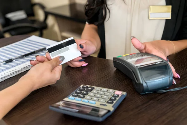 Kredi kartlı kadın elleri ve güzellik salonunda terminal.