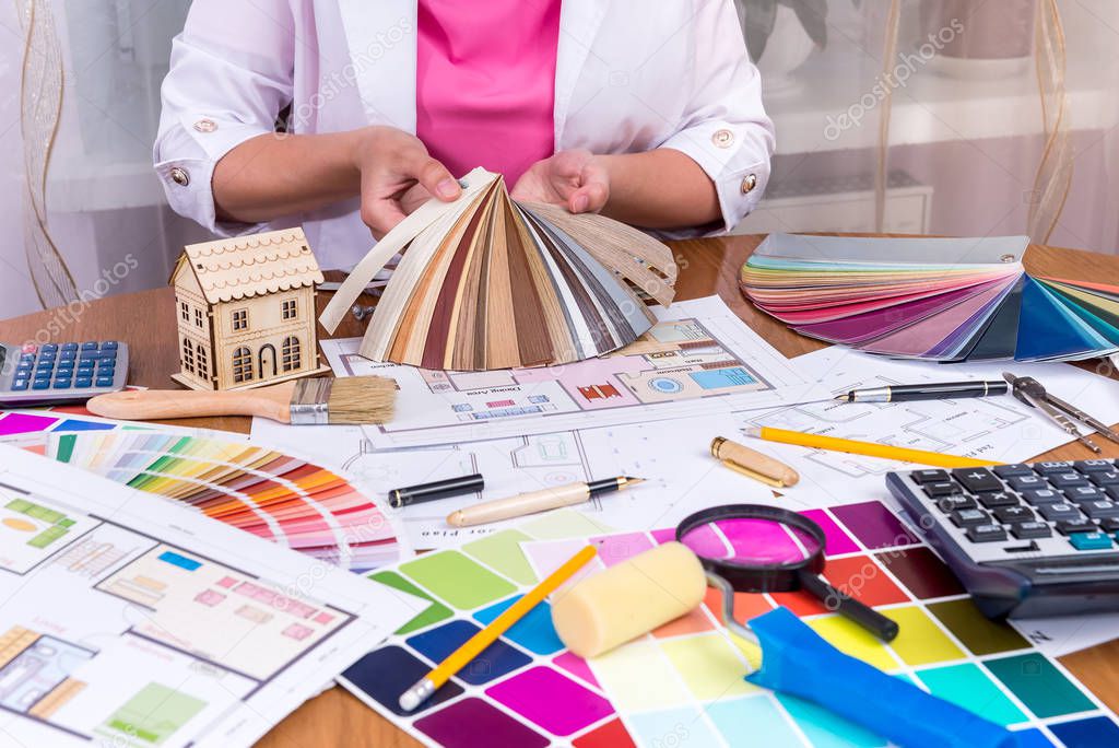 Designer's hands showing colourful sampler at workplace