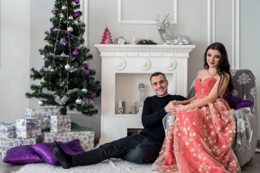 Stüdyoda şöminenin yanında poz veren mutlu çift