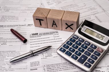 1040 individual tax form with pen and calculator