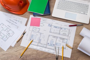 Yeni projeyle birlikte mimarın çalışma yeri ahşap masanın üzerinde.