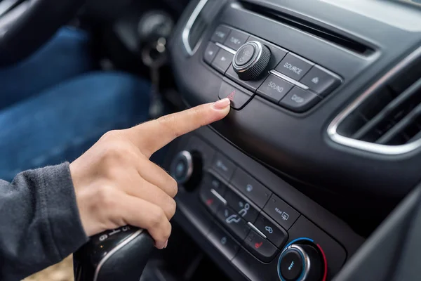 Жіночий палець, що вказує на кнопку аварійної зупинки крупним планом — стокове фото