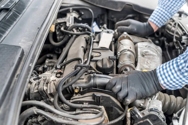 手袋をして労働者の手で車のエンジン — ストック写真