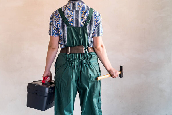 Женщина-работница с набором инструментов и молотком

