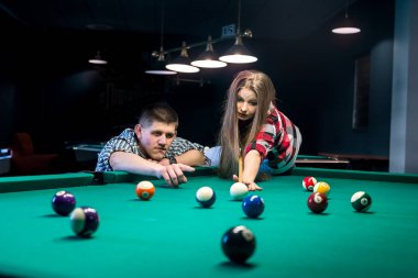 Atış için topu tutan adam, bilardo oynayan çift.