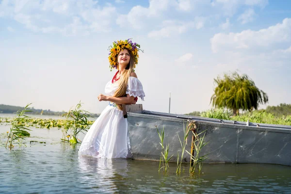 Gölü boylayan, ulusal kıyafetler içinde güzel bir kız.