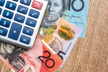 Ahşap bir masa Avustralya Doları hesap makinesi