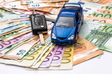 Oyuncak otomobil ve avro banknotunun arka planında gerçek anahtarlar