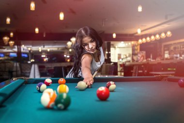 Esmer, Amerikan bilardosu oynayarak vakit geçiriyor.