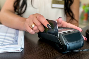 Kredi kartı ve terminali olan kadın elleri