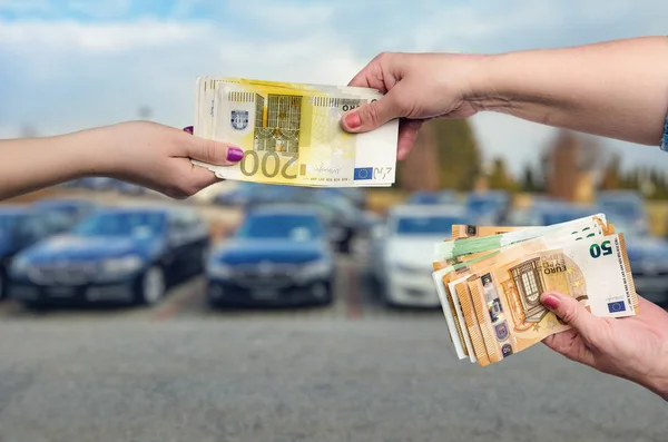 Car as background for female hands with euro banknotes