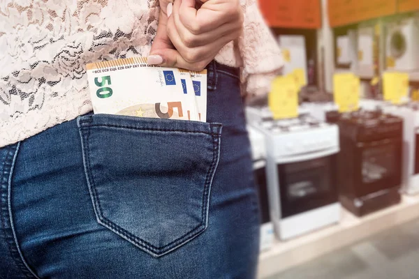 Покупки в магазине бытовой техники, банкноты евро в кармане — стоковое фото