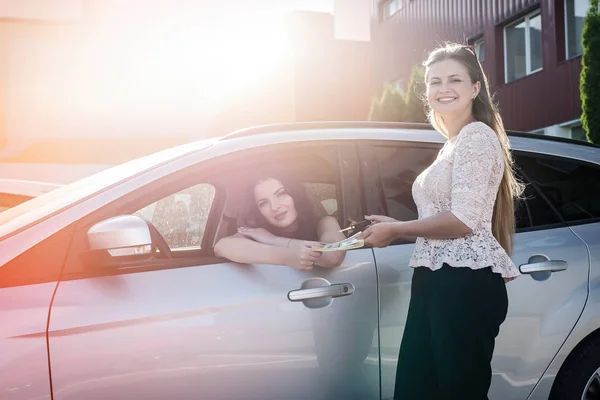 Two Beautiful Women Exchanging Dollars Car Keys — 스톡 사진