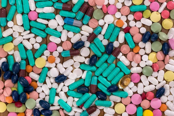 Comprimidos Coloridos Dispersos Tampas Mesa Madeira — Fotografia de Stock