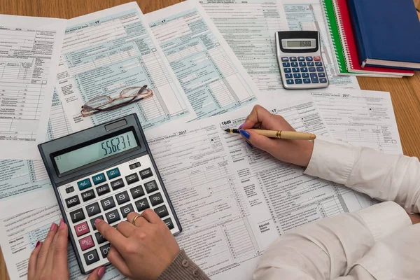 Mano femenina con pluma que llena el formulario de impuestos 1040 —  Fotos de Stock