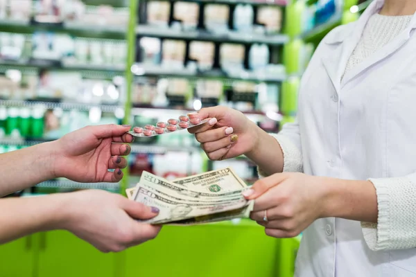 药剂师和消费者手里拿着药丸和钱 — 图库照片