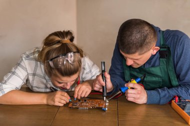 Young couple of engineers repairing computer device