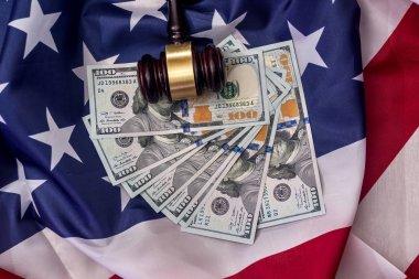Amerikan bayrağında dolar banknotları olan yargıç tokmağı.