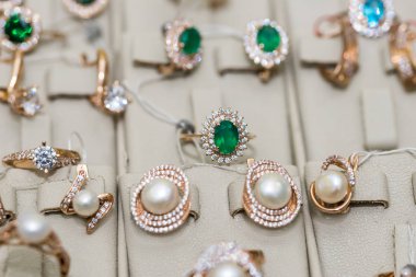 Vitrinde inci ve değerli taşları olan altın mücevherler.