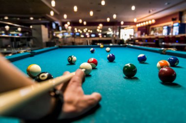 Masada bilardo topuna nişan almış bir el.