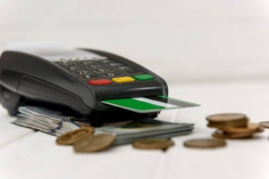 Bozuk paralı dolarlar ve kredi kartlı banka terminali.