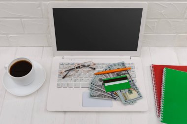 Laptop, kredi kartı, dolar ve kahve fincanı.