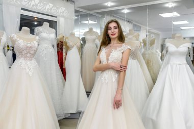Gelinlikli güzel gelin butikte duruyor.