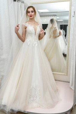 Salondaki genç gelin aynaya bakıyor.