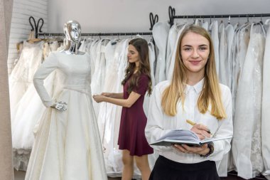 Genç tasarımcılar kuafördeki gelinlikte çalışıyorlar.