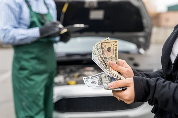 Manos femeninas con dólares, pago por servicio de coche —  Fotos de Stock
