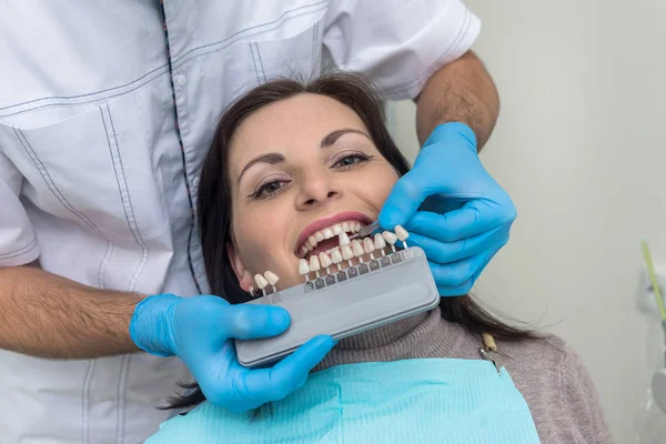 Médico comparar dientes de mujer con muestreador en odontología — Foto de Stock