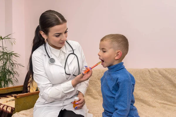 Dokter met medicament in spuit en kleine jongen — Stockfoto