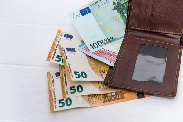 Банкноти євро з коричневим гаманцем на столі. — стокове фото