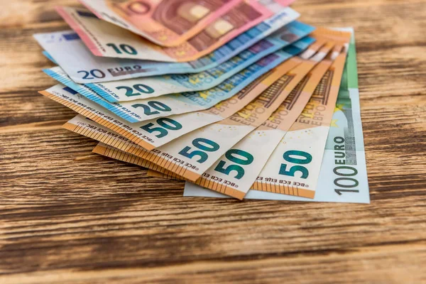 Банкноты евро в вентиляторе на деревянном столе — стоковое фото