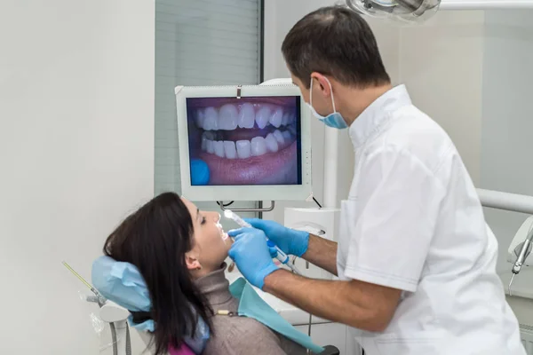 Dentista examinando los dientes del paciente con cámara intraoral — Foto de Stock