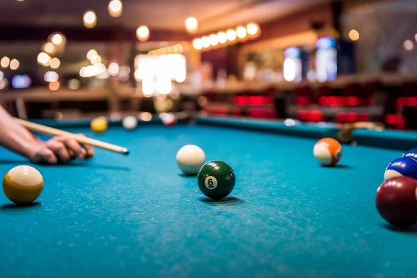 Hand with cue aiming on billiard ball at table — Stock Photo, Image