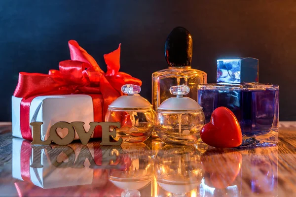 Czerwone serce z pudełkiem i butelkami perfum — Zdjęcie stockowe
