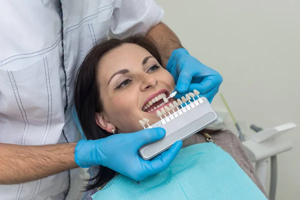 Médico comparar dientes de mujer con muestreador en odontología — Foto de Stock