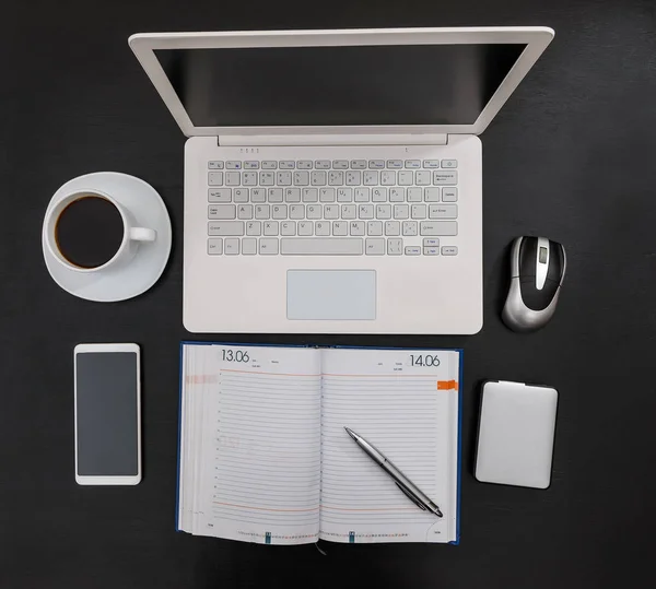 Draufsicht am Laptop mit Tagebuch auf schwarzem Hintergrund — Stockfoto