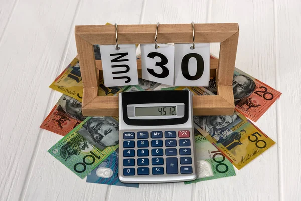 Υπολογιστής με ξύλινο ημερολόγιο και αυστραλιανά τραπεζογραμμάτια δολαρίου — Φωτογραφία Αρχείου
